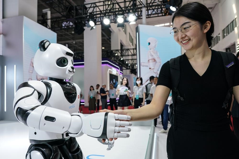 2023年8月16日，一名女士在北京舉辦的2023世界機(jī)器人大會(huì)現(xiàn)場(chǎng)與智能機(jī)器人握手。新華社記者彭子洋攝