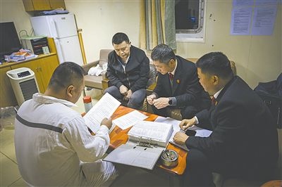 圖②：法官向船長講解相關法律規(guī)定，查看船舶資料，并與船方辦理扣押船舶的手續(xù)。