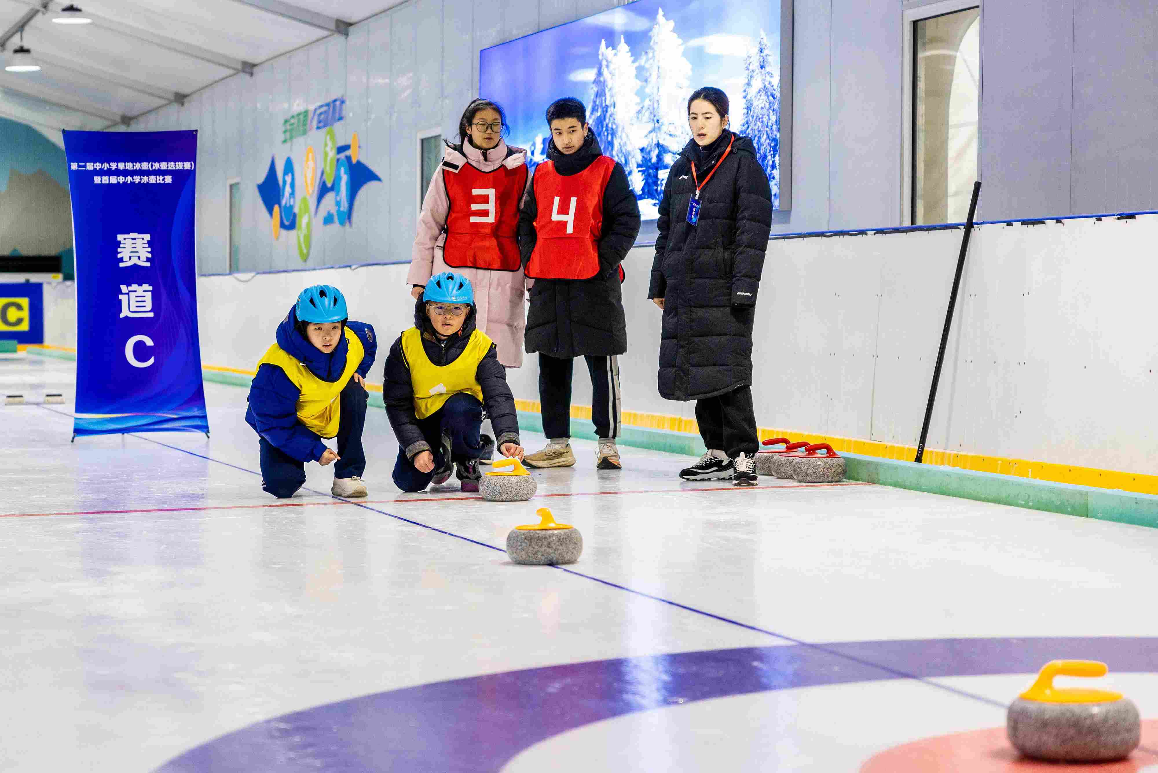 2023年12月10日，參賽選手在呼和浩特首屆中小學(xué)冰壺比賽中投擲冰壺。