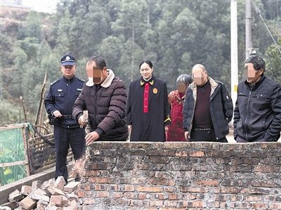  圖③：庭審結(jié)束后，在法官的見(jiàn)證下，陳某在院壩邊重新開(kāi)鑿一條通道。
