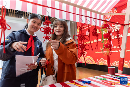 1月28日，復(fù)旦大學(xué)第二附屬學(xué)校學(xué)生（左）為美國(guó)馬斯卡廷中學(xué)學(xué)生（右）介紹中國(guó)結(jié)。 新華社記者 王翔 攝