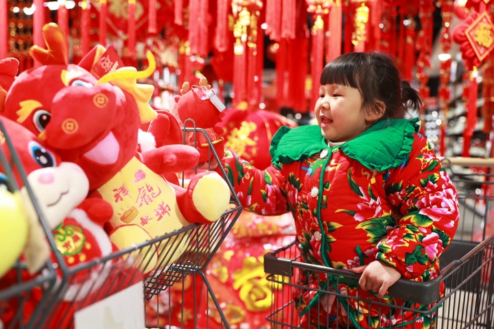 1月23日，在貴州省黔東南苗族侗族自治州岑鞏縣一家超市，小朋友在家人的帶領(lǐng)下選購龍年毛絨玩具。新華社發(fā)（唐鵬攝）