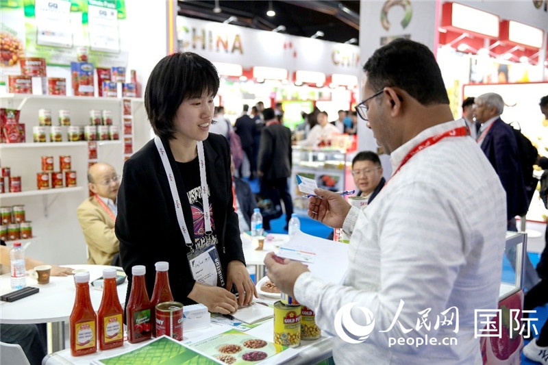 圖為中國參展企業(yè)代表與采購商交流。人民網(wǎng) 塔里克·易卜拉欣攝