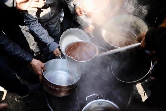 2月27日，在加沙地帶北部的杰巴利耶難民營(yíng)，人們領(lǐng)取食物。新華社發(fā)（穆罕默德·阿里攝）