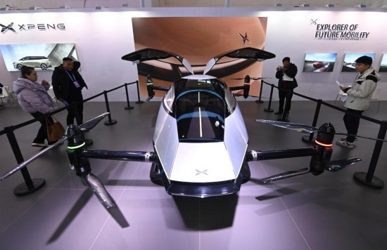 2023年12月1日，在鏈博會智能汽車鏈展區(qū)小鵬汽車展臺，參觀者觀看一臺智能飛行器。新華社記者蔡湘鑫攝