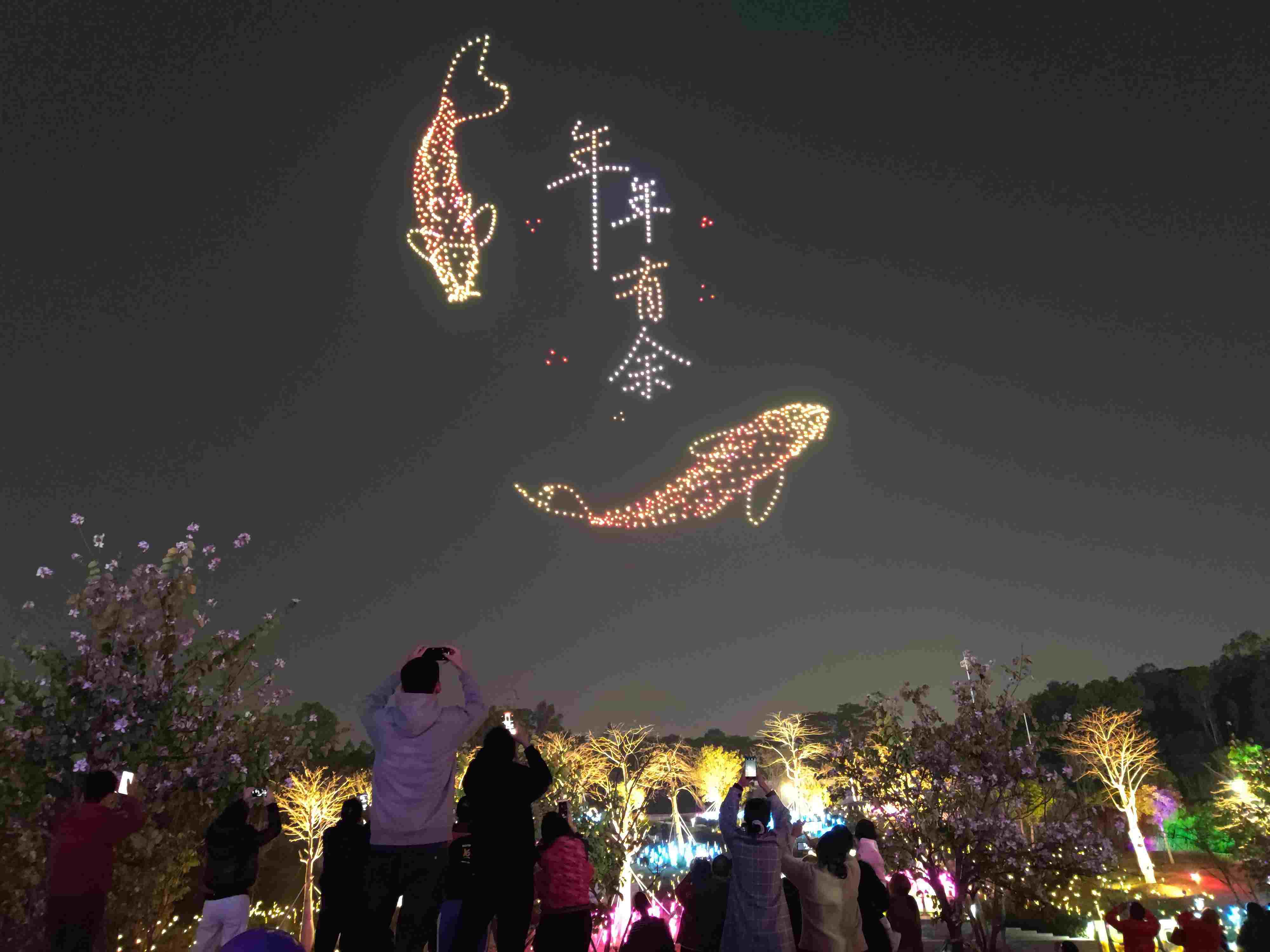 △ 2024年2月10日，深圳北站中心公園，春節(jié)主題無人機(jī)燈光秀引來眾多游客駐足觀看。
