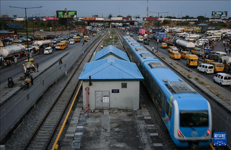 3月4日，在尼日利亞拉各斯，一列輕軌藍(lán)線列車行駛至公路交通擁堵路段附近。新華社記者 韓旭 攝