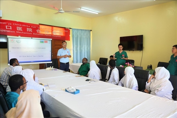 隊長蔣國慶和韋長群醫(yī)生一起解答問題。中國援桑醫(yī)療隊供圖