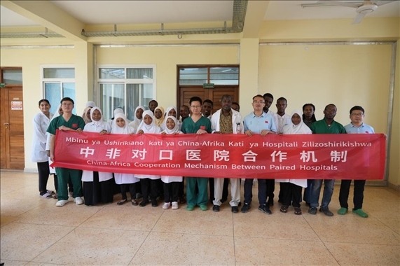 醫(yī)療隊隊員和當?shù)蒯t(yī)生們合影。中國援桑醫(yī)療隊供圖