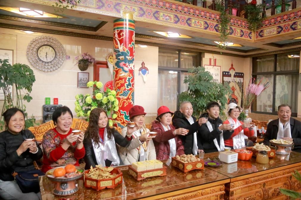 游客們?nèi)胱∶袼藓?，舉杯共飲酥油茶。新華社記者 邱星翔 攝