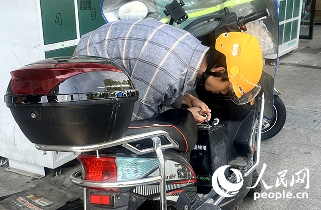 杭州一名外賣(mài)騎手正在更換共享電池。人民網(wǎng)記者 張麗瑋攝