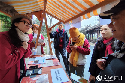 1月6日，“2024成都蒲江柑甜采摘節(jié)”上，記者見到了小萌（左一）和許多年輕人忙著做訪客接待、現(xiàn)場布置、票務(wù)核對(duì)、采摘服務(wù)等工作。人民網(wǎng)記者朱虹攝