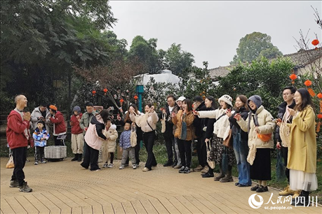 葉科（左一）給前來參與活動(dòng)的“柑爸柑媽”介紹生態(tài)種植果。人民網(wǎng)記者朱虹攝