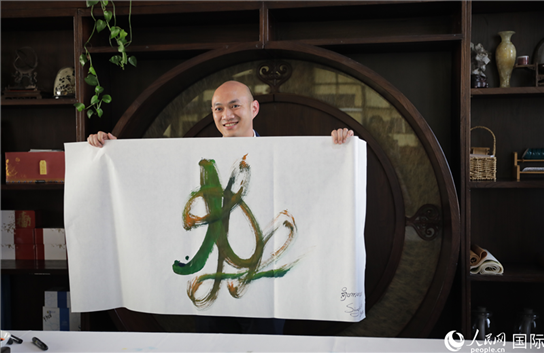 老撾駐華大使館三秘明君參加《五百筆·瀾湄合作》集體藝術(shù)創(chuàng)作。人民網(wǎng)王婧攝。