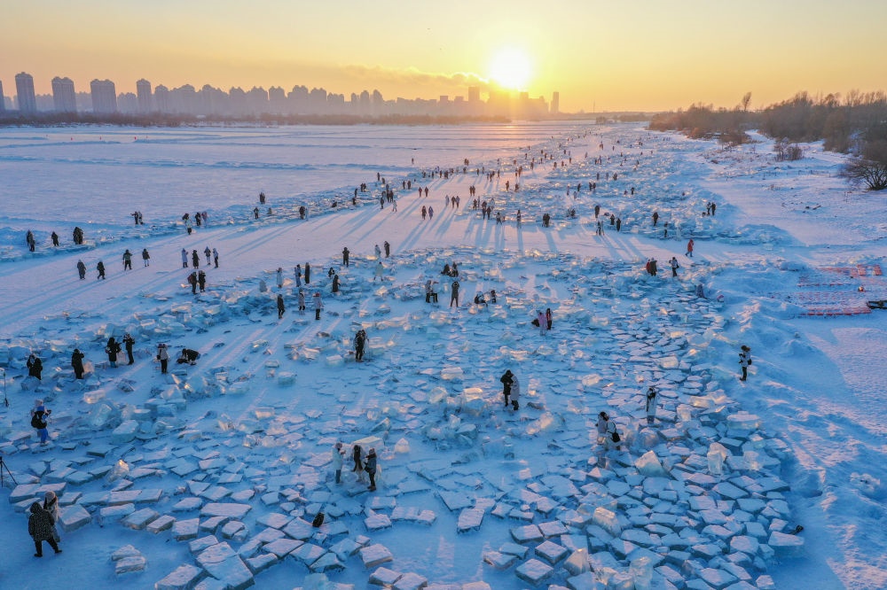2024年1月7日，在封凍的松花江哈爾濱段，游客在日落時分的“鉆石?！庇瓮妫o人機照片）。新華社記者 謝劍飛 攝