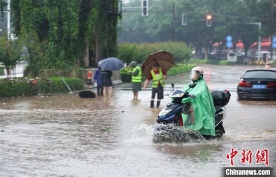 5月10日，廣西沿海遭遇強降雨。圖為欽州市民眾在積澇中出行。陸敏 攝