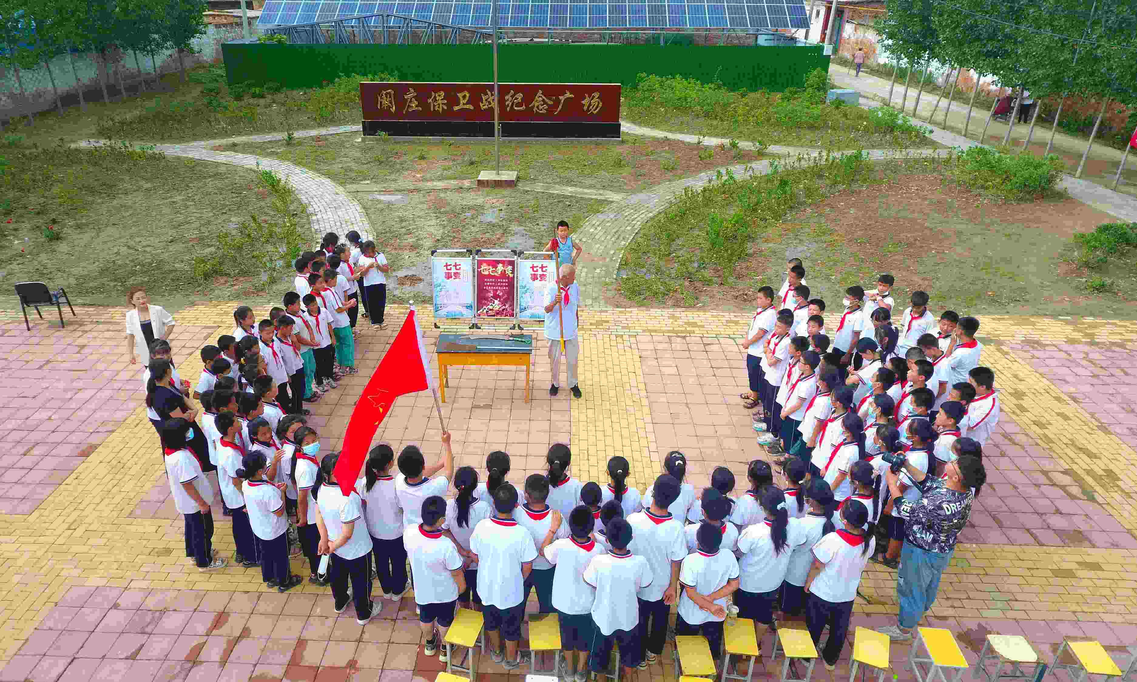 2022年7月6日，山東省聊城市，在茌平區(qū)菜屯鎮(zhèn)闞莊村的闞莊保衛(wèi)戰(zhàn)紀(jì)念廣場(chǎng)，闞莊保衛(wèi)戰(zhàn)親歷者王光木老人為小學(xué)生們講述抗戰(zhàn)故事，展示大刀、長(zhǎng)矛。