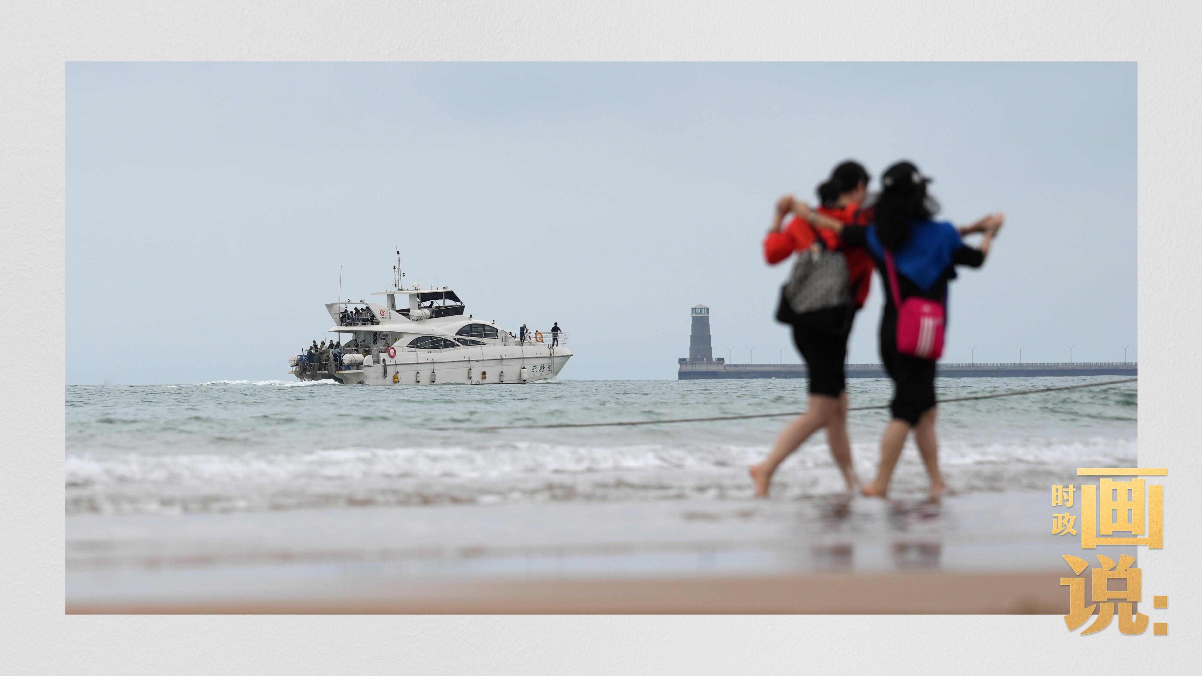 △日照陽光海岸綠道上的萬平口景區(qū)，一對游客在海浪中翩然起舞。