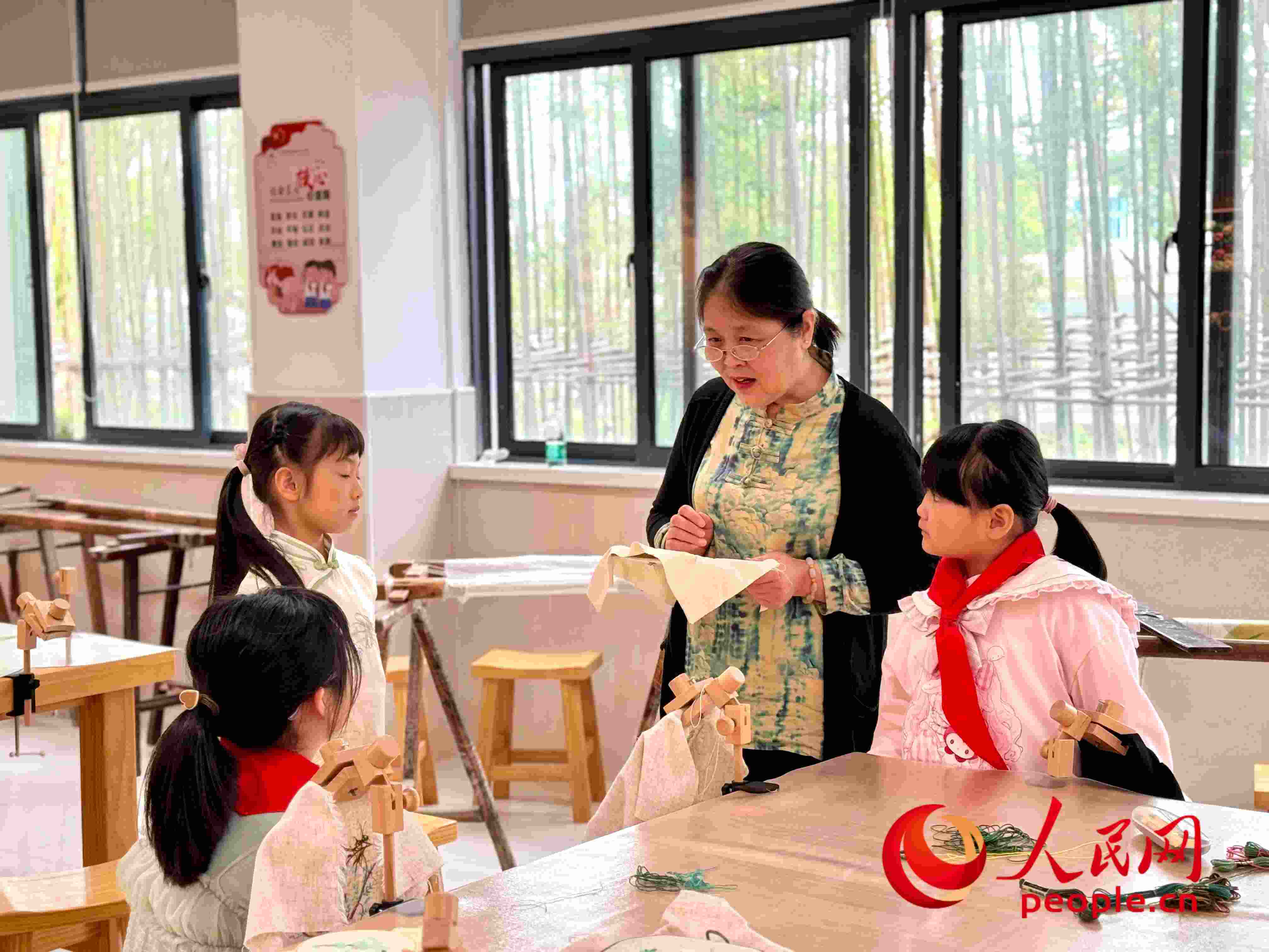 顧建珍（左三）在教孩子們刺繡知識(shí)。人民網(wǎng) 周靜圓攝