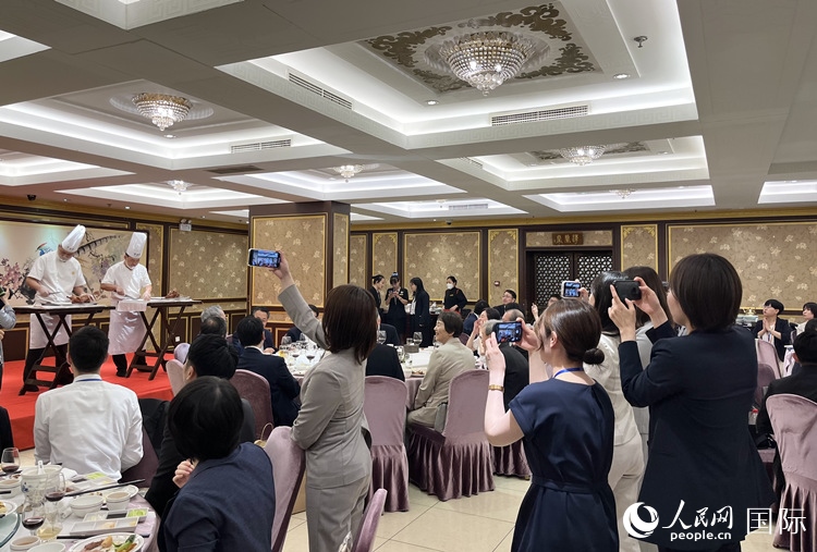 國家級非物質(zhì)文化遺產(chǎn)、全聚德片鴨工藝吸引代表團成員拍照留念。