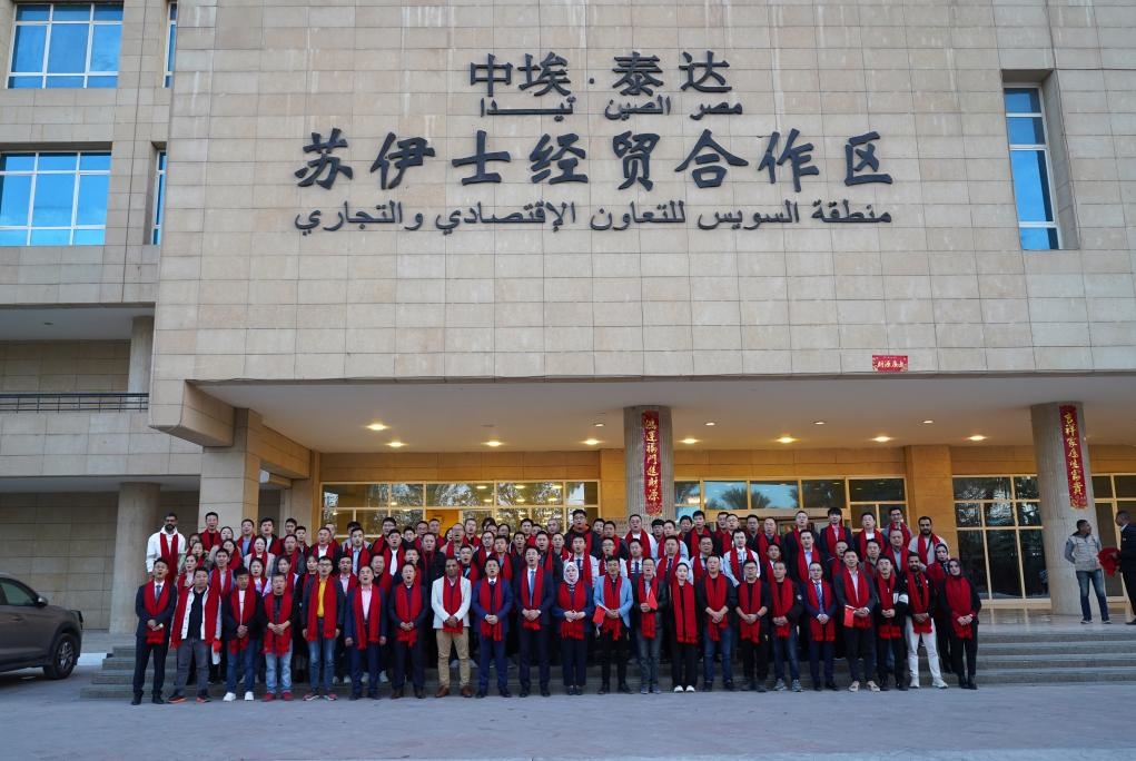 2024年2月11日，在位于埃及蘇伊士省的中?！ぬ┻_(dá)蘇伊士經(jīng)貿(mào)合作區(qū)，中埃員工在合作區(qū)辦公大樓前合影拜年。新華社發(fā)（泰達(dá)合作區(qū)供圖）