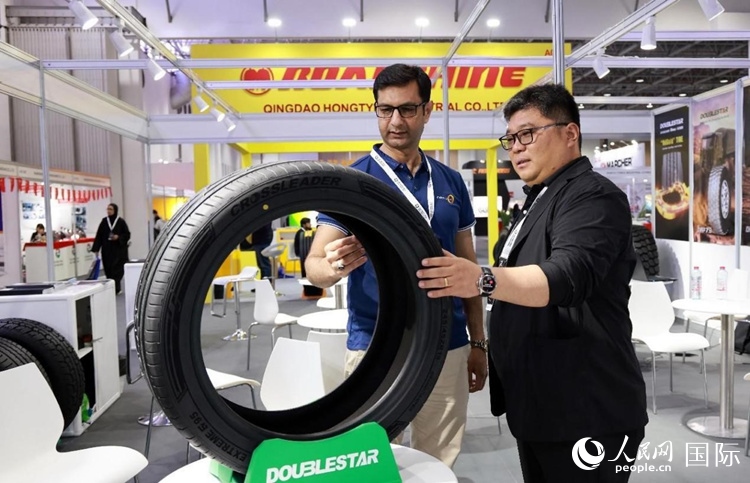 工作人員向客戶展示雙星電動(dòng)汽車(chē)輪胎。和傳統(tǒng)汽車(chē)輪胎相比，電動(dòng)汽車(chē)輪胎具有更高承載能力、更加靜音舒適、更好極速抓地、更低滾動(dòng)阻力等特點(diǎn)。人民網(wǎng)記者 管克江攝