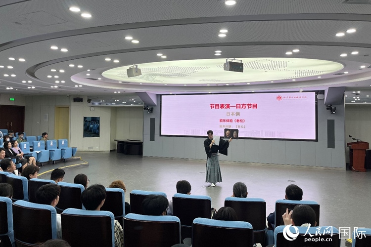 日本大學(xué)生介紹能樂(lè)知識(shí)。人民網(wǎng)記者 陳思攝