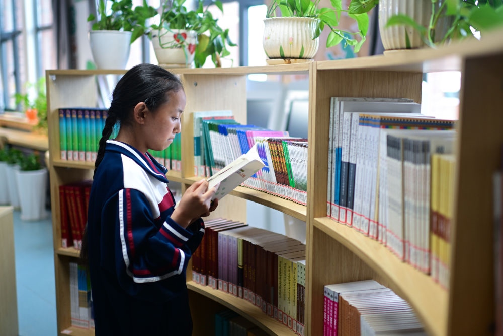6月18日，果洛西寧民族中學(xué)學(xué)生尼東拉毛在圖書室看書。