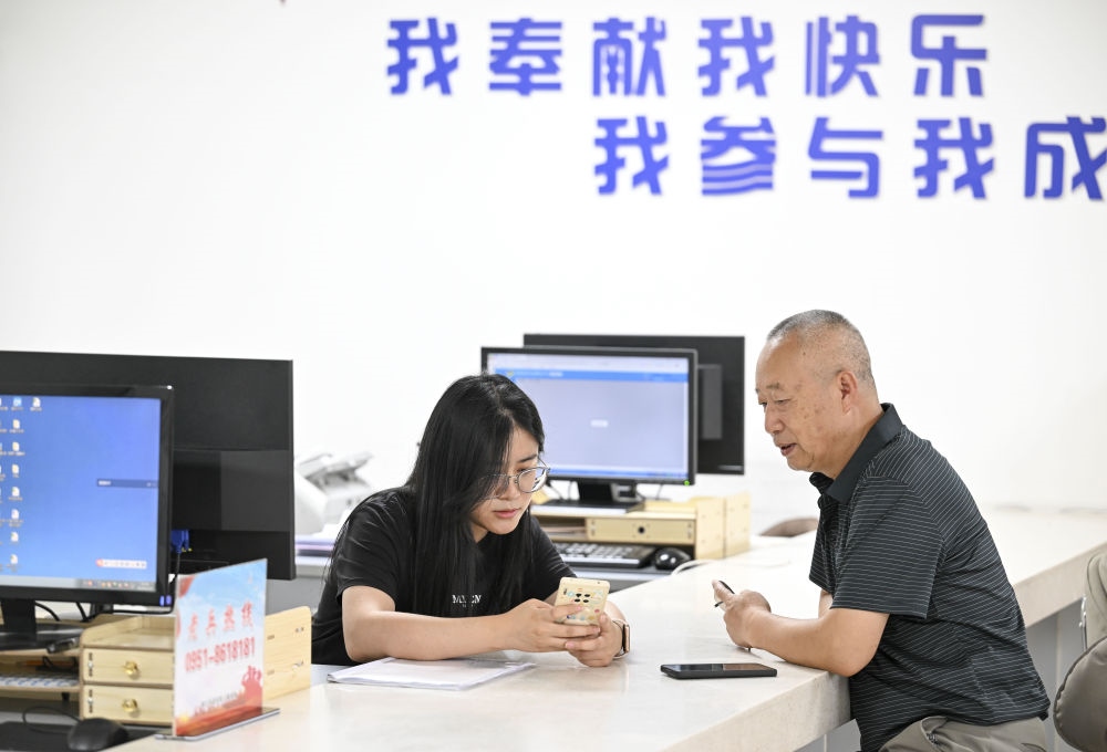 6月20日，在長城花園社區(qū)黨群服務中心，工作人員幫助居民辦理業(yè)務。