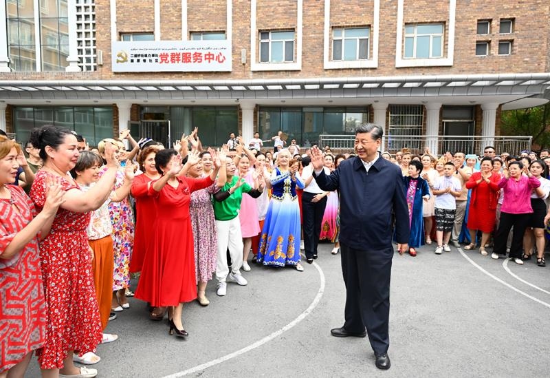 2022年7月13日，習(xí)近平總書記在新疆烏魯木齊市天山區(qū)固原巷社區(qū)考察時(shí)，向各族群眾揮手致意。