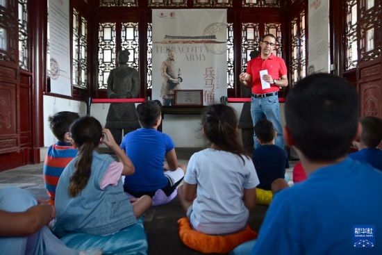 7月4日，在馬耳他桑塔露琪亞市的中國古典園林“靜園”，人們聆聽關(guān)于兵馬俑的講解。新華社發(fā)（喬納森·博格 攝）
