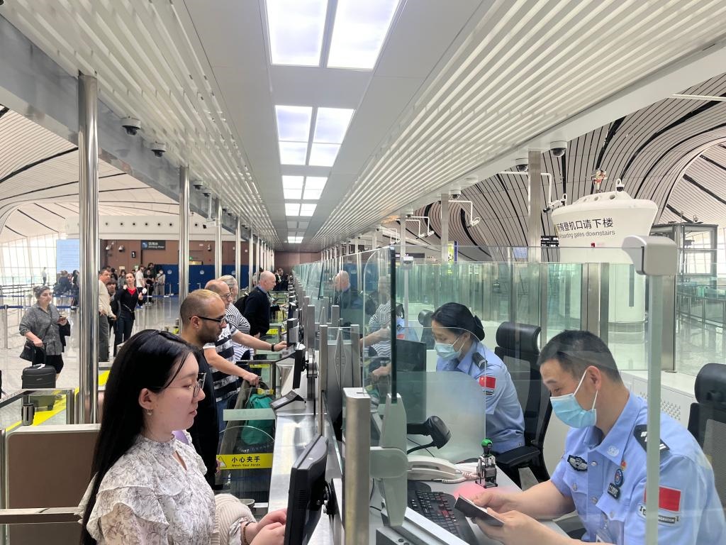 7月5日，北京大興國(guó)際機(jī)場(chǎng)邊檢站民警正在辦理邊檢查驗(yàn)手續(xù)。（北京大興國(guó)際機(jī)場(chǎng)邊檢站供圖）