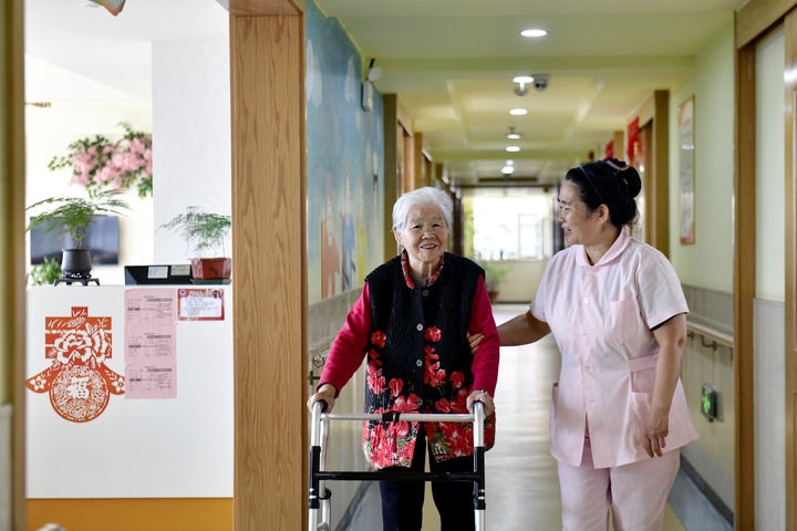 2024年5月25日，在山東省日照市東港區(qū)石臼街道日照幸福護(hù)理院，工作人員在陪護(hù)老人。新華社記者 郭緒雷 攝