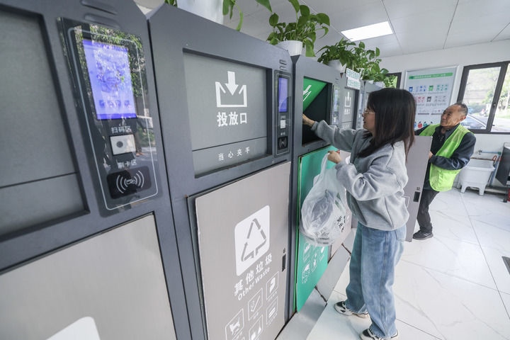 2024年4月10日，在浙江省湖州市吳興區(qū)飛英街道新華府小區(qū)內(nèi)，居民在垃圾分類智能系統(tǒng)的指導(dǎo)下進(jìn)行垃圾分類投放，居民的投放情況將實時匯總到智慧服務(wù)平臺，會有相應(yīng)的積分獎勵。新華社記者 徐昱 攝