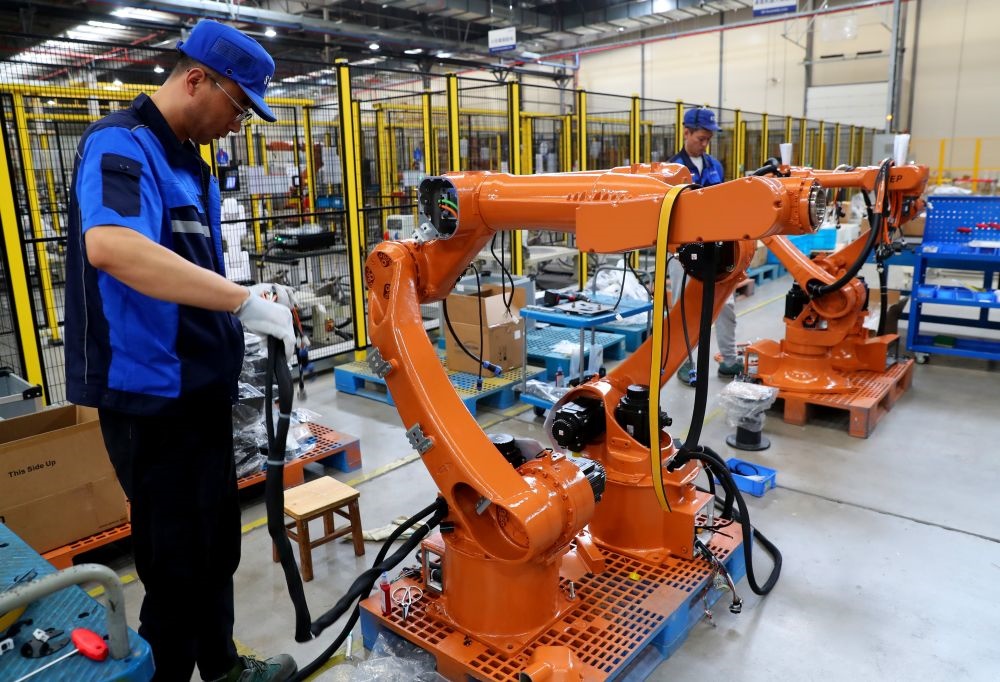 工作人員在上海新時(shí)達(dá)機(jī)器人有限公司位于嘉定的智能工廠內(nèi)忙碌（2024年5月23日攝）。新華社記者 龔兵 攝