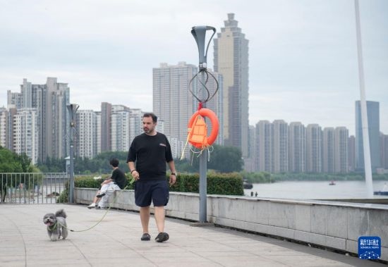 7月20日，在安徽蕪湖市，馬丁在長江邊遛狗。新華社記者 傅天 攝
