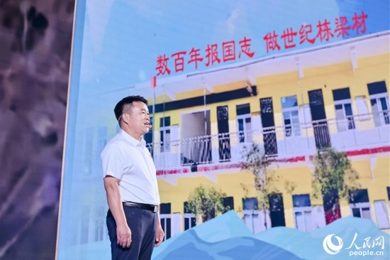 張玉滾分享用一根扁擔(dān)送孩子們走出大山的故事。人民網(wǎng)攝