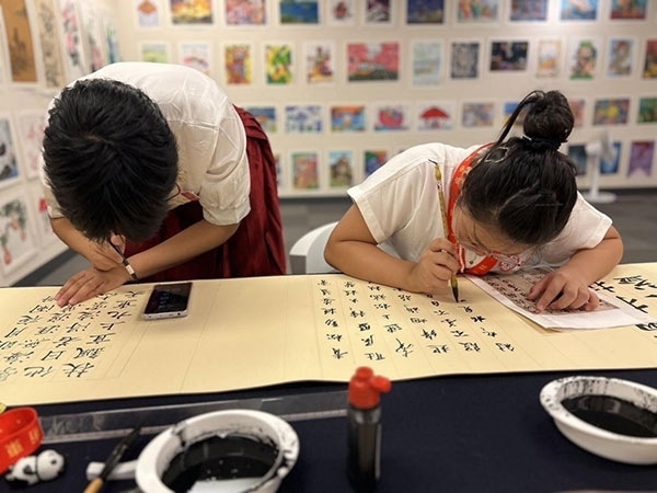 參加本次展覽的青少年在現(xiàn)場進(jìn)行書法創(chuàng)作。主辦方供圖