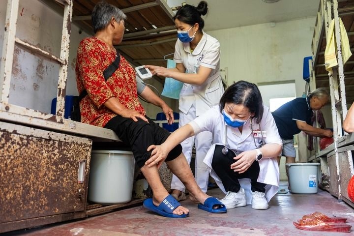 2024年7月30日，在湖南省湘潭縣河口中學安置點，醫(yī)務人員為受洪水影響而轉移安置的群眾檢查身體。 新華社記者 陳思汗 攝