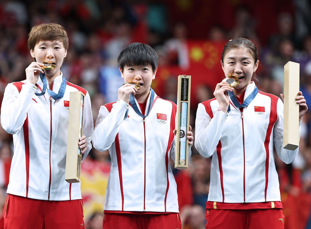 冠軍中國隊選手王曼昱、孫穎莎、陳夢（從左至右）在巴黎奧運會乒乓球女子團(tuán)體頒獎儀式上（2024年8月10日攝）。新華社記者 王東震 攝