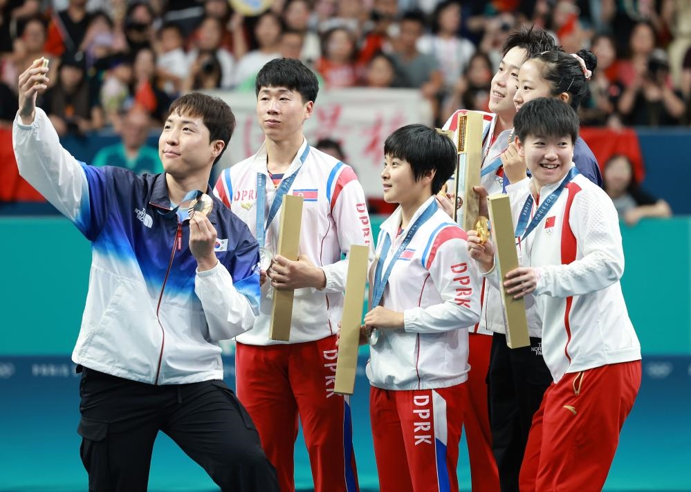 冠軍中國組合王楚欽（右三）/孫穎莎（右一）、亞軍朝鮮組合李正植（左二）/金琴英（左三）、季軍韓國組合林鐘勛（左一）/申裕斌在巴黎奧運會乒乓球混雙頒獎儀式上合影（2024年7月30日攝）。新華社記者 劉續(xù) 攝
