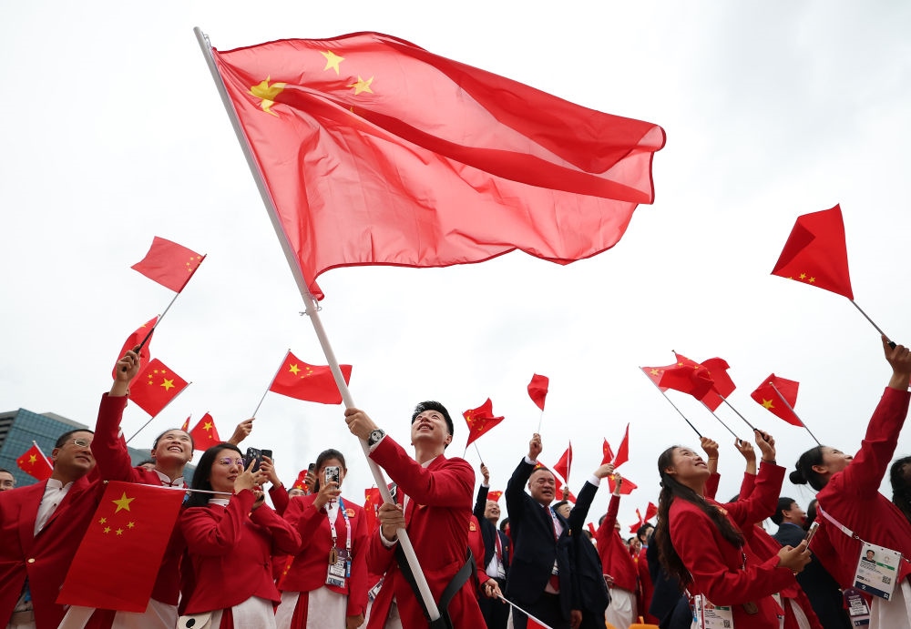 中國體育代表團(tuán)旗手、乒乓球選手馬龍在第33屆夏季奧林匹克運動會開幕式前揮舞國旗（2024年7月26日攝）。新華社記者 曹燦 攝