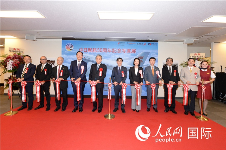 與會嘉賓共同為中日通航50周年紀(jì)念圖片展開幕剪彩。馮學(xué)敏攝