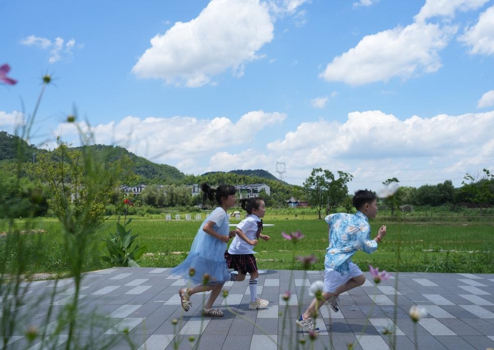 兒童在余姚市梁弄鎮(zhèn)的田野間奔跑（7月3日攝）。新華社記者翁忻旸 攝