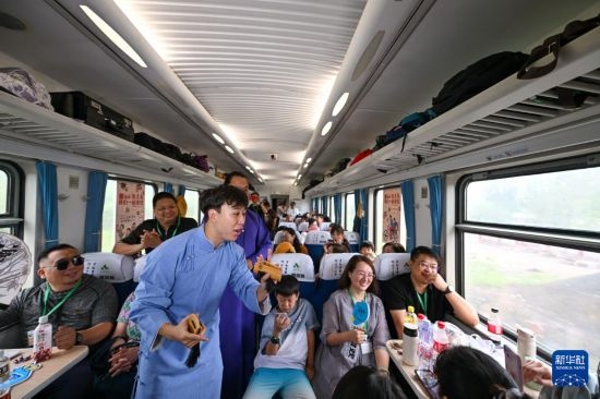 9月7日，相聲演員在S910列車上為旅客表演快板。