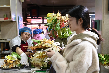 游客挑選好麻辣燙菜品后排隊(duì)等待加工。新華社記者 范培珅 攝