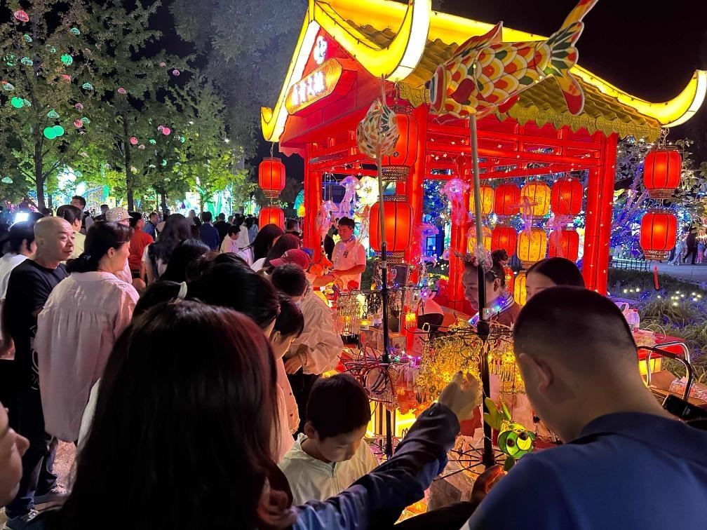 市民游客在2024年北京中秋國(guó)慶彩燈游園會(huì)上選購(gòu)特色文創(chuàng)商品。新華社記者楊淑君 攝