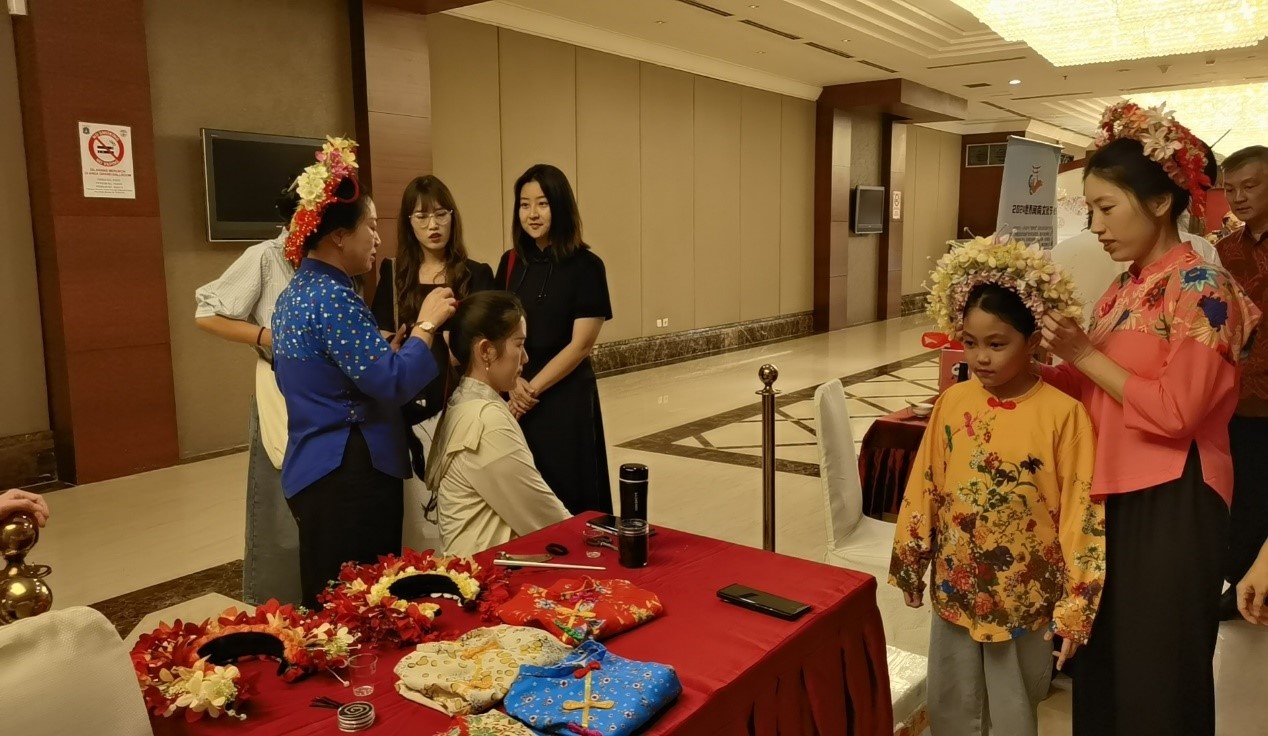 阿拉扎大學(xué)孔子學(xué)院志愿者老師向傳承人學(xué)習(xí)簪花圍。阿拉扎大學(xué)孔子學(xué)院供圖