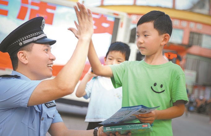▲7月10日，江西省吉安市公安局吉州分局組織民警深入轄區(qū)開展安全宣傳，民警向小朋友講解防溺水知識。朱文杰攝
