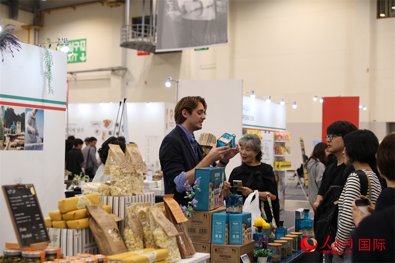 當?shù)貢r間10月5日，在第21屆釜山國際美食博覽會上，意大利展商向參觀者們介紹的意大利食品。人民網(wǎng)記者 莽九晨攝